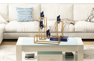 4 decorative pieces placed on a coffee table of a man sitting on a gold base frame and thinking