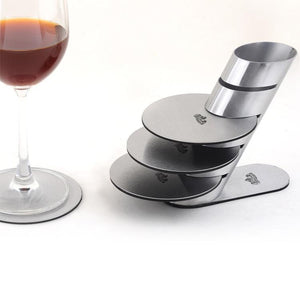 stainless steel coasters on a stand and a glass of wine
