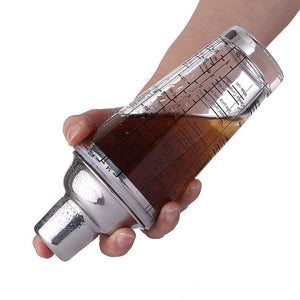 hand holding a glass cocktail shaker