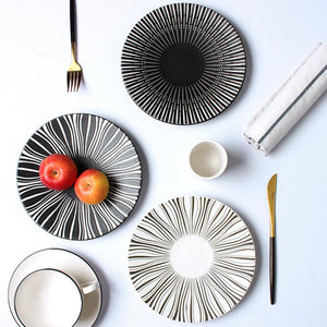 2 PLATES FROM THE DEJAVU DINNERWARE COLLECTION PLACED ON A TABLE SETTING
