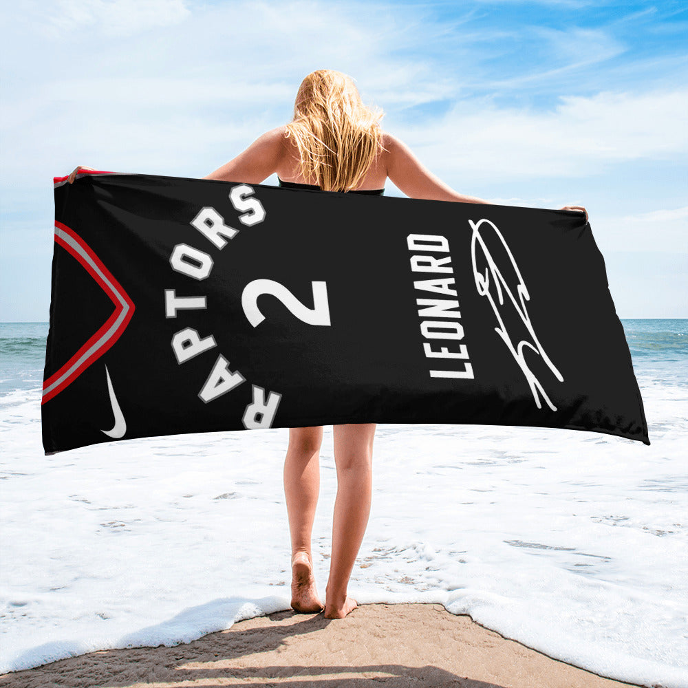 girl on the beach holding a beach towel with kawhi leonard's jersey printed on it