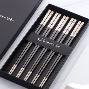 5 pairs of grey and off white chopsticks in a black box