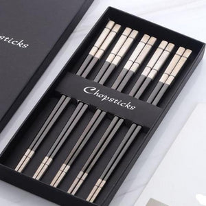 5 pairs of grey and off white chopsticks in a black box