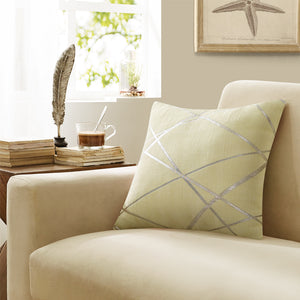 tan colored cushion with gold geometric stripes placed on a beige couch -FunkChez
