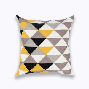 mix of yellow, black, brown and white in geometric patterns printed on a cushion cover