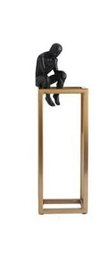 decorative figurine of a man statue sitting on a gold rectangular tower