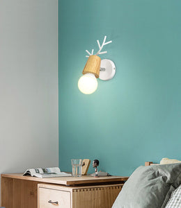 Ahorn wall lamp with white base fixed on a teal wall over a desk 