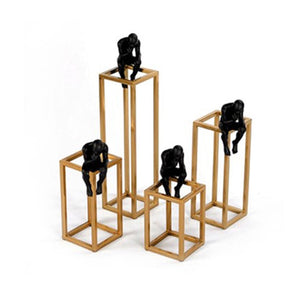 4 decorative pieces of a man sitting on a gold base frame and thinking