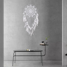 Load image into Gallery viewer, white dreamcatcher hanging on a grey wall over a table