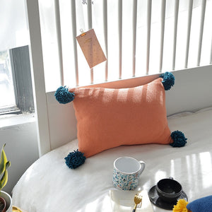 orange cushion with blue tassels on all four ends FunkChez