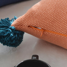 Load image into Gallery viewer, closeup of a concealed zip on an orange cushion with a blue tassel 