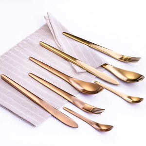ombre cutlery set of knives forks and spoons placed on a pink tablecloth