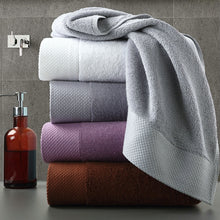 Load image into Gallery viewer, set of 4 luxury towels stacked near a hand wash on a vanity counter