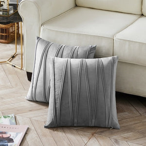 2 cushions in grey from the Nordane cushion collection placed besides a couch