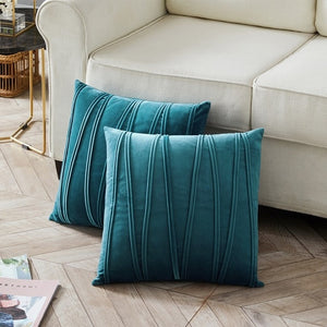 2 cushions in blue from the Nordane cushion collection placed besides a couch