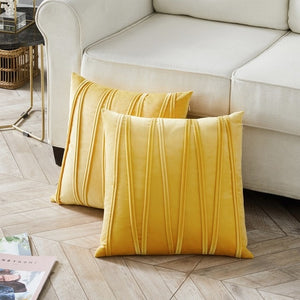 2 cushions in mustard yellow from the Nordane cushion collection placed besides a couch