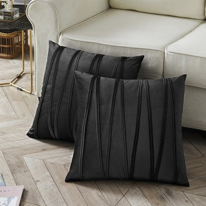 2 cushions in black from the Nordane cushion collection placed besides a couch