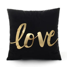 Load image into Gallery viewer, The word love printed in gold on a black polyester throw pillow 