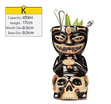 Load image into Gallery viewer, black and cream ceramic tiki tumbler in the shape of a skull filled with cocktail and some veggies with size specs